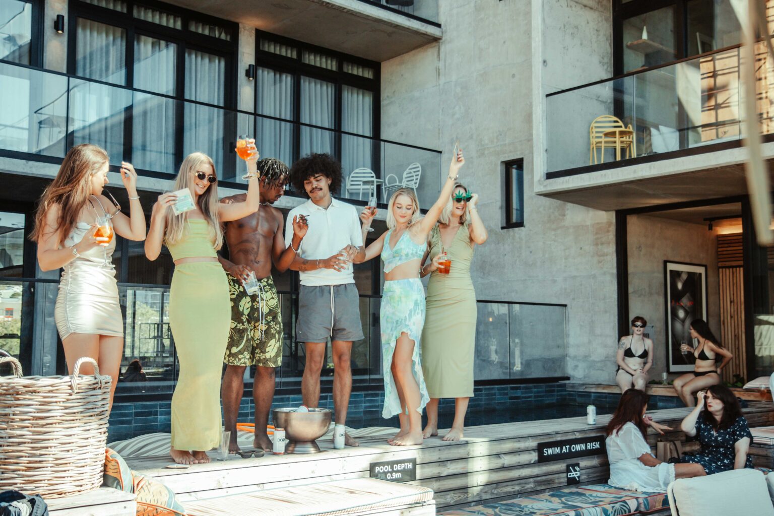 A group of friends gathered with drinks on the rooftop terrace