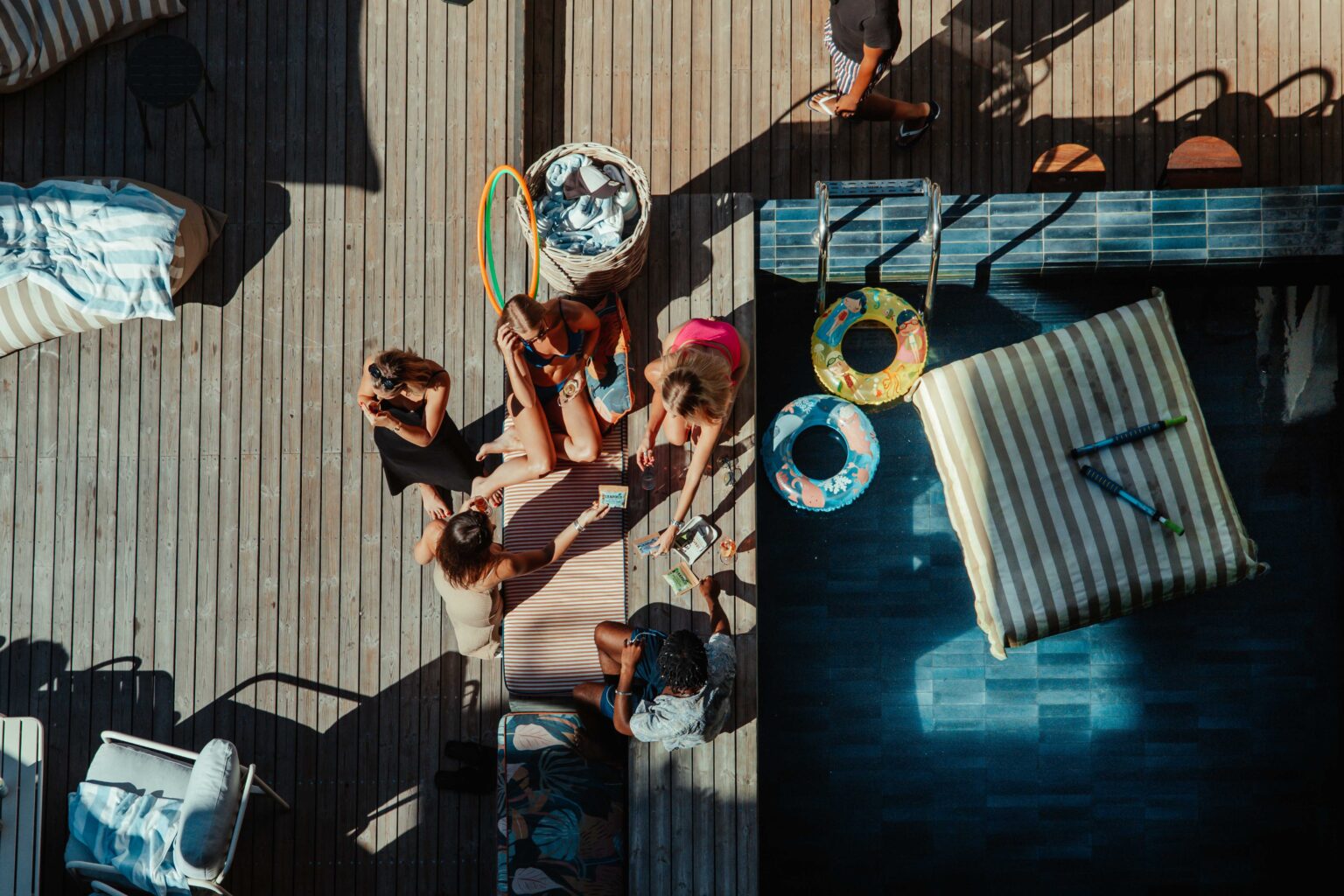 Overhead view of guests gathered beside the rooftop pool and loungers